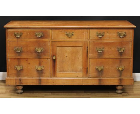 A 19th century farmhouse pine low dresser, rectangular top above and arrangement of short drawers and a panel door enclosing 
