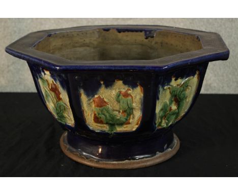 A 20th century Chinese pottery octagonal shaped garden planter decorated with panels of flowers raised on circular foot. H.25