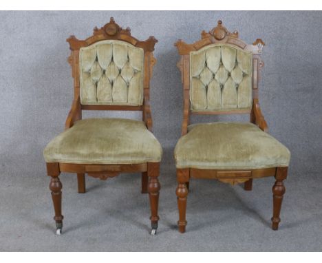 A pair of 19th century Gothic Revival walnut framed button back chairs raised on turned supports terminating in ceramic caste