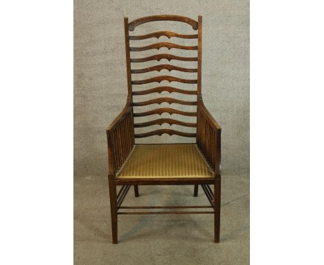 A 19th century Arts &amp; Crafts mahogany ladder back armchair, the high arched back with ten splats and the arms with spindl