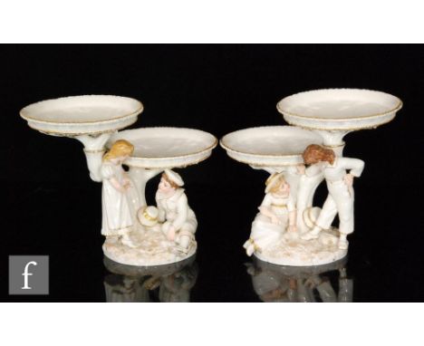 A pair of Royal Worcester figural two tiered comports modelled by James Hadley in the style of Kate Greenaway, circa 1860s, t