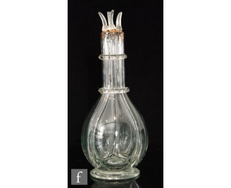 A 19th Century quatrefoil spirit decanter, of footed ovoid form with two ringed neck, with four later stoppers, height 32cm. 