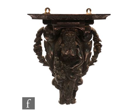 A 19th/20th Century carved oak wall bracket, the apostle and acanthus leaves forming the lower pediment, and supporting a can