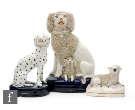A 19th Century Staffordshire figure group of a poodle with a puppy seated to a domed blue cushion base, height 17.5cm, togeth