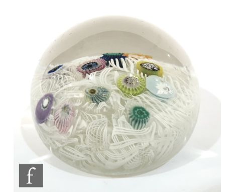 A 20th Century scramble glass paperweight, possible Italian with random millefiori canes over a white lattachino cane ground.