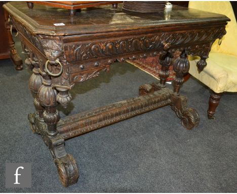 A Victorian carved oak centre table fitted with a single drawer and lion corner mask ring drop handles on twin pillar support