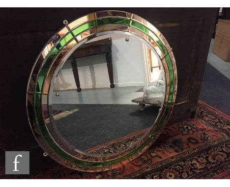 An Art Deco bevelled glass wall mirror of circular form, with green and peach coloured borders, diameter 75cm. 