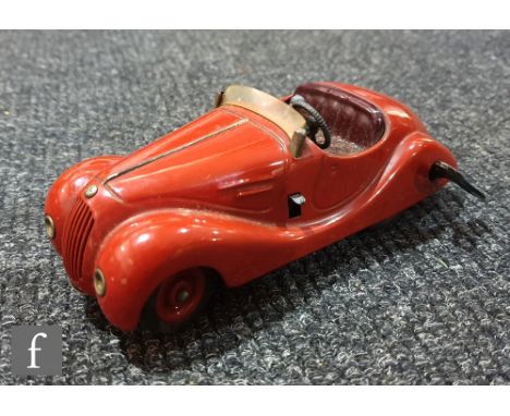 A Schuco Examico 4001 tinplate clockwork car in red with maroon seats, windscreen and key, with partial broken box and instru