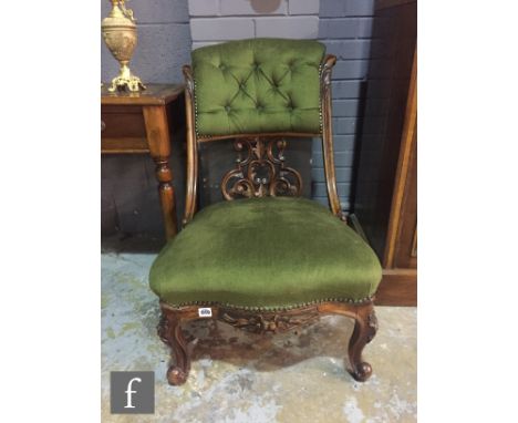 A Victorian mahogany scroll back nursing chair, with serpentine edge seat on cabriole legs, upholstered in green plush. 