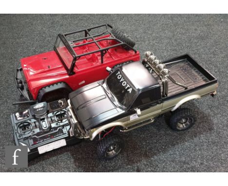 An Axial AX90021 1:10 scale SCX10 Dingo kit, built, with a Tamiya 1:10 scale radio control Toyota 4x4 Pick-up Truck 58397 Hil