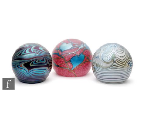 An Okra glass paperweight with the amethyst ground decorated with iridescent pulled trails in blue, engraved signature and da