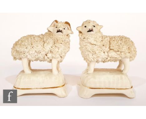 A pair of 19th Century Staffordshire figures of a ram and sheep mounted to cushion form bases. (2) 