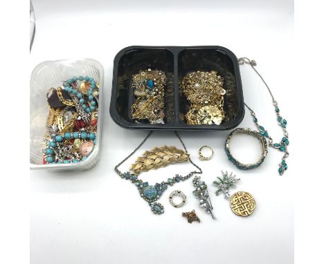 2 Tubs filled with vintage costume jewellery which includes brooches, bracelets, earrings and necklaces 