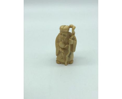 An antique hand carved ivory netsuke of an old man with cane. Signed by the artist. possibly meiji period. Measures 5cm in he