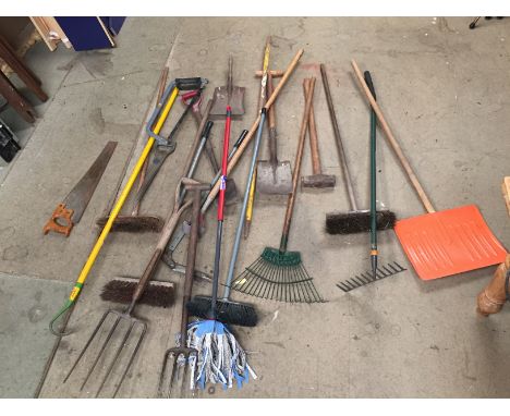 A selection of garden tools forks, rakes, hoes and a sledgehammer.