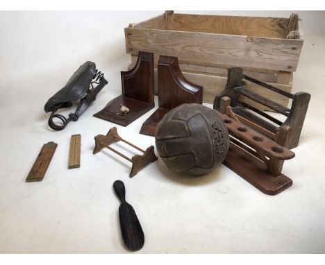 A vintage Dunlop bike saddle also with a pre war leather lace up football and a wooden fruit crate together with two pipe rac