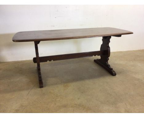 A early Ercol dark elm dinning table with stretcher bar and pegs. No stamp W:182cm x D:69cm x H:71cm