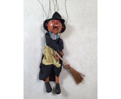 Early Pelham puppet in blue-label box. Witch on broomstick with wooden peg teeth and drop lead hands. Some stains to apron bu