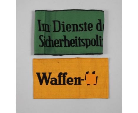 Zwei Armbindenum 1940, "Im Dienste der Sicherheitspolizei“, gedruckt auf grünem Tuch, oben und unten schwarzer Kettelstreifen