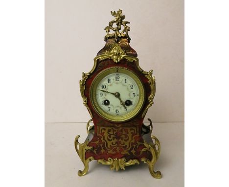 An early 20th century French gilt brass and boulle work mantle clock having an enamelled dial over raised brass feet 