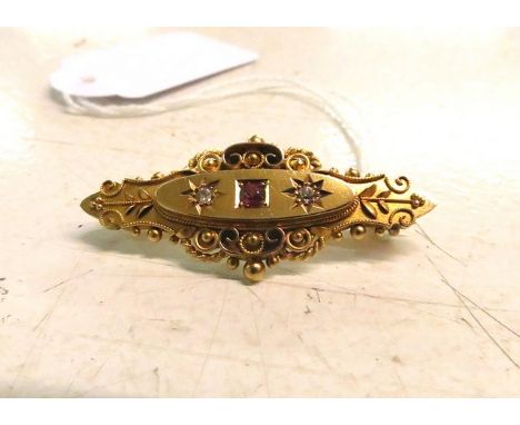 A Victorian 15ct yellow gold brooch set with a ruby and two old mine cut diamonds 