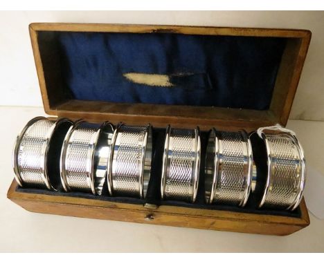 A leather cased set of six Birmingham silver engine turned napkin rings 