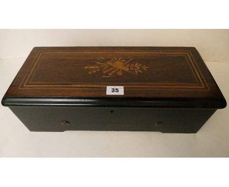 A small early 20th century musical box with a marquetry inlaid lid and playing six airs 