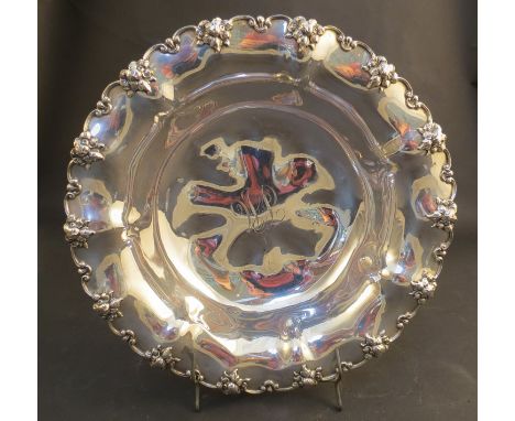 A Sterling silver floral shaped bowl with scroll and flower border, monogrammed to centre, Birmingham, 352g