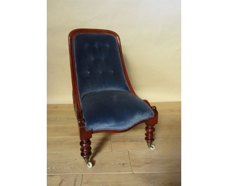 An early Victorian mahogany spoon back open armchair the button back over a serpentine front seat on turned legs and white ce