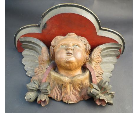 A 19th Century polychrome wall clock bracket with carved winged cherub decoration, 34cm long