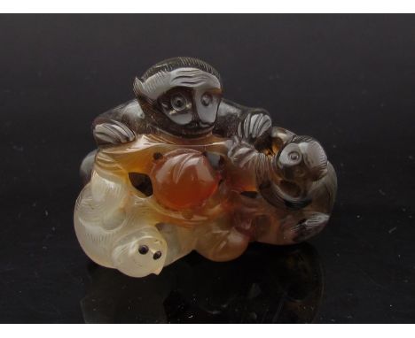 A Chinese jade group of monkey and babies eating peaches, 4.5cm long