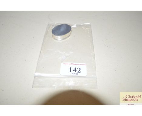 A white metal oval pill box, the lid decorated with vintage motor car