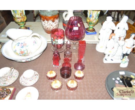 A collection of Cranberry and other glassware to include oil lamp base, Whitefriers vase, an overlaid glass bottle and stoppe