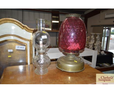 A brass oil lamp with ruby glass dimpled shade and another 