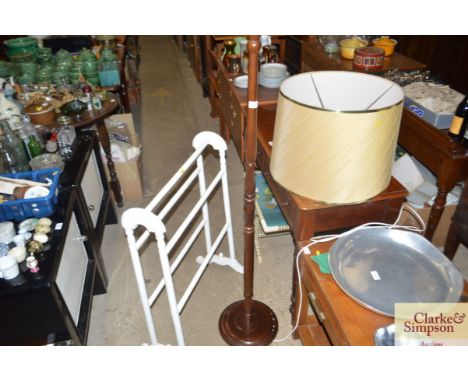 A white painted towel rail and a standard lamp and shade 