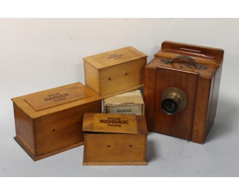 A TEAK AND BRASS 10" x 8" BELLOWS CAMERA, with brass Beck symmetrical lens and three Kodak film tanks in wooden cases, one wi