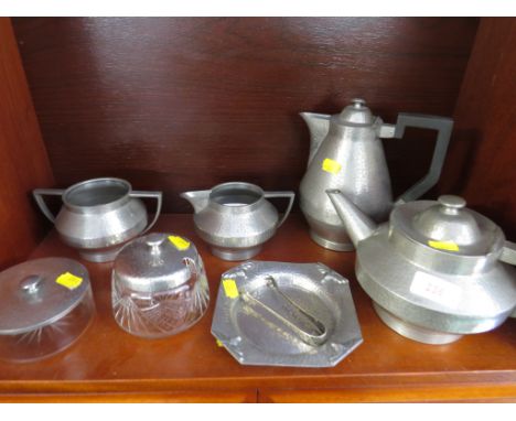 A BATTLE AXE BRAND PLANISHED PEWTER TEA SET , TWO CUT GLASS JARS WITH PEWTER LIDS AND A SHALLOW PEWTER DISH.