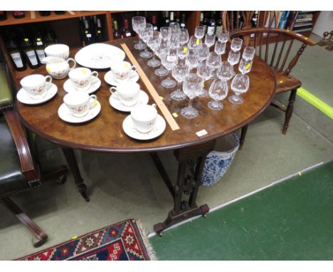 19TH CENTURY WALNUT VENEERED GATE LEGGED SUTHERLAND TABLE ON BRASS CASTERS.