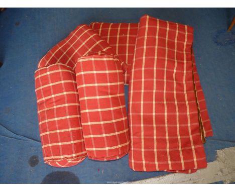 A quantity of red sofa cushions and throws.