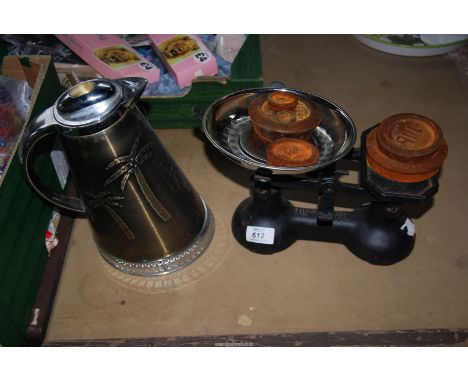 A money box in the form of a jug and a set of scales with weights.