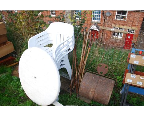 A garden roller, wooden draining rods, six stacking chairs and table.