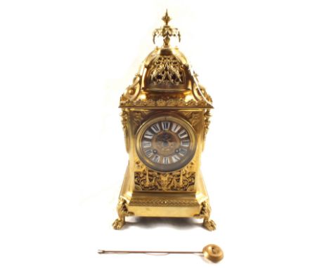 A French gilt metal clock garniture with enamelled numbers and a pair of two branch candelabra