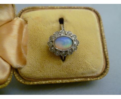 A Gold ring with central opal and diamond surround