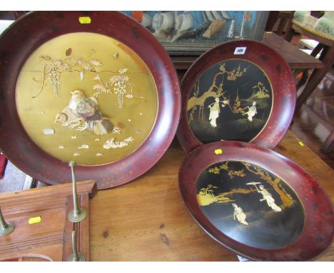 ORIENTAL LACQUER, pair of circular wall plaques decorated with mother-of-pearl and carved bone figures in riverscape setting,