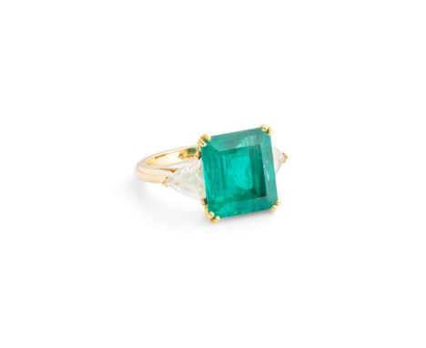  A Colombian emerald and diamond ring  The step-cut emerald, weighing 7.67 carats, in a double four-claw setting, between tri