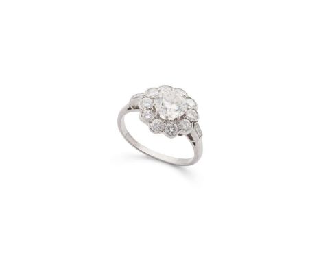  A diamond cluster ring  The brilliant-cut diamond, in a ten-claw setting, within a scalloped similarly-cut diamond surround,