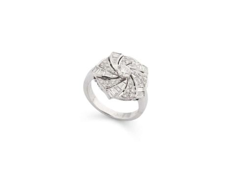  A diamond swirl ring  The central brilliant-cut diamond, within a swirling surround of similar, tapered baguette and baguett