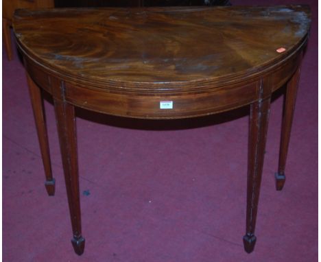 An early 19th century mahogany and inlaid demi-lune fold-over card table