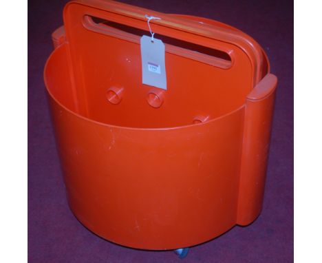 A 1980s Italian orange moulded polypropylene portable occasional table, with pull-up and fold-out leaves, raised on roller ca