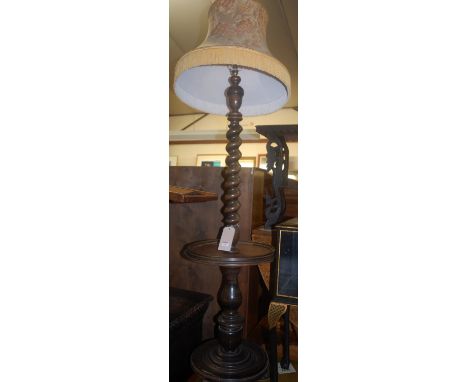 A barleytwist turned walnut and oak standard lamp, having a dished centre